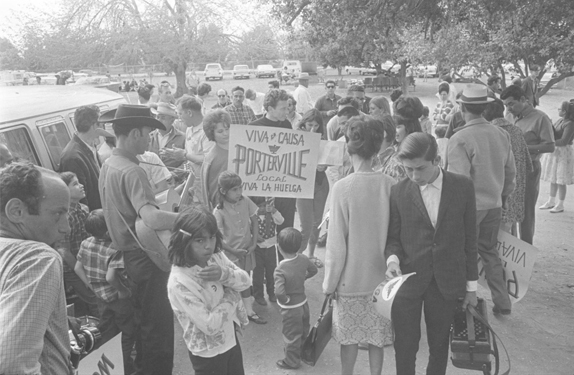 Oscar Garza at a farm worker protest in 1966, (the boy in the vest (chaleco) holding the “Viva la Causa” and “Viva la Huelga” protest sign)